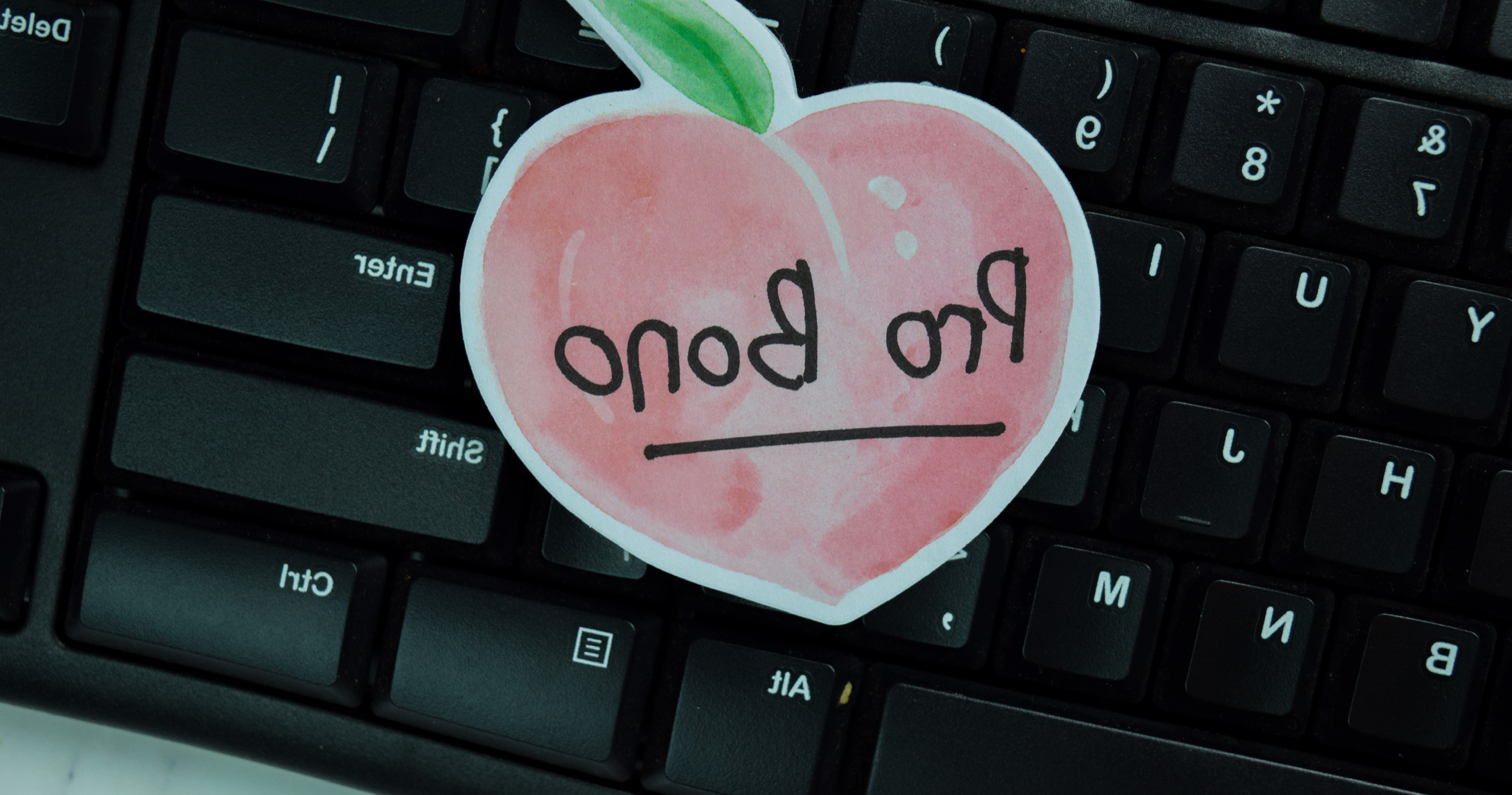 手绘的桃子在黑色的电脑键盘上写着“公益”